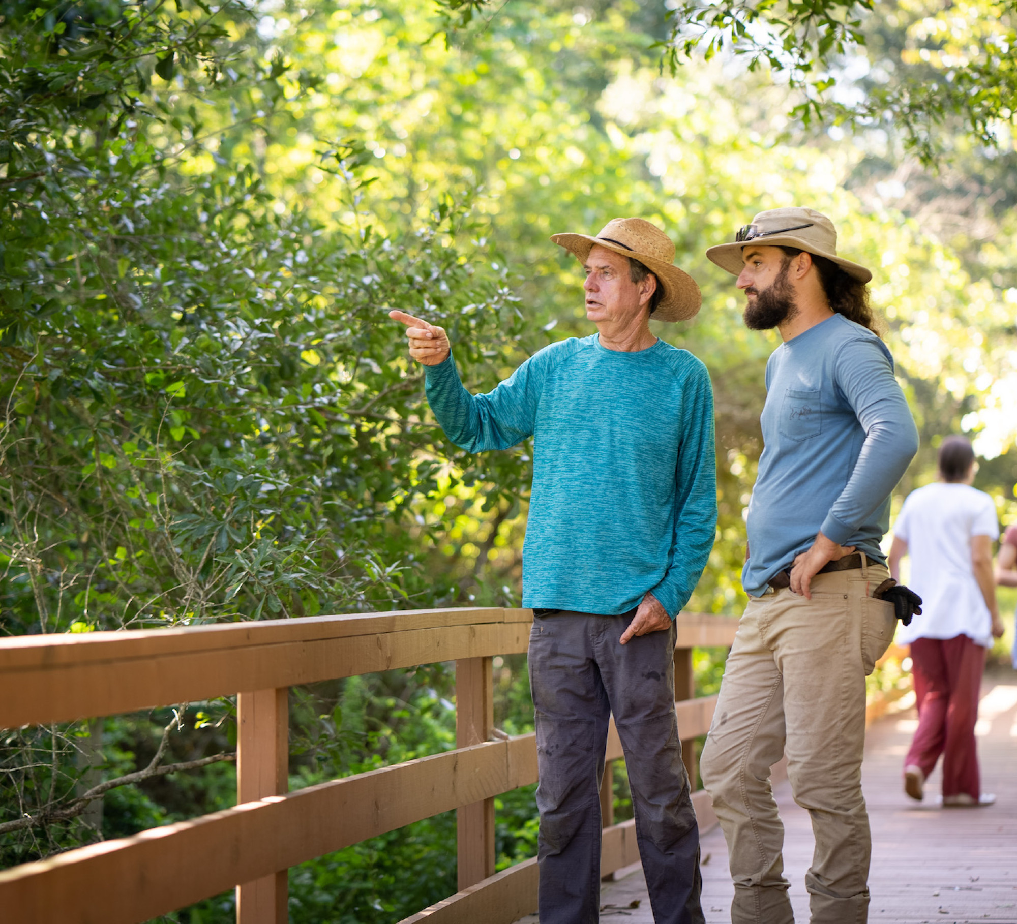 Two men talking on a bridge in a trail park